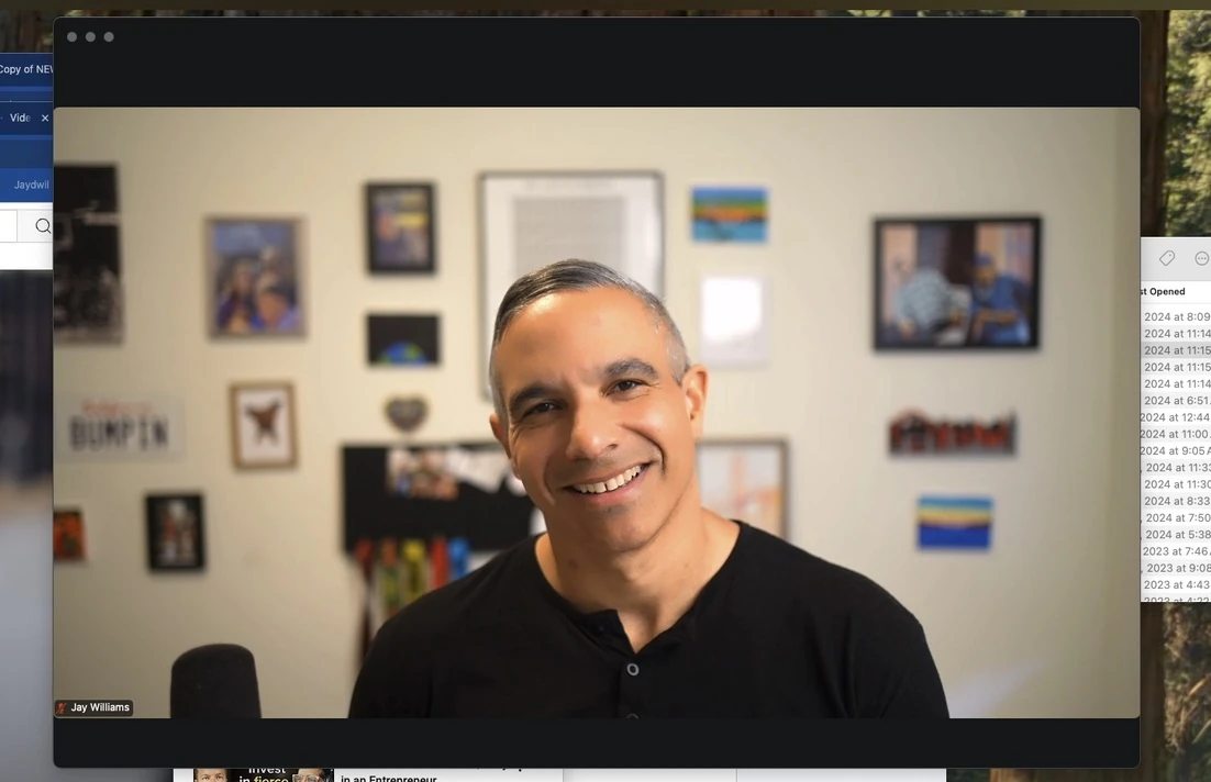Jay smiling toward the camera in a black polo during a video call